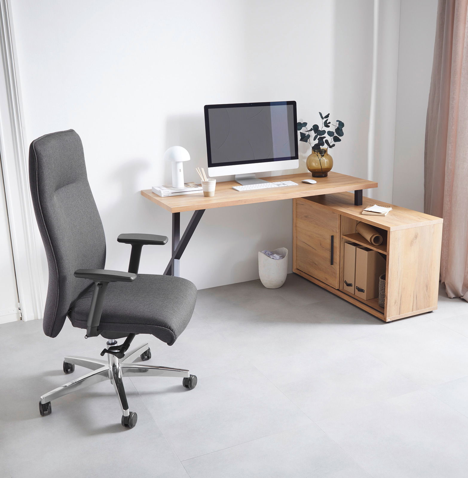 Eck-Schreibtisch-Kombination aus Holz mit integriertem Stauraum, abgebildet aus einer seitlichen Perspektive. Ein moderner Bürostuhl steht daneben, und ein Computer mit Zubehör befindet sich auf dem Schreibtisch.