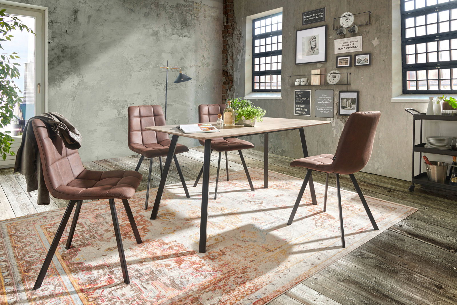 Esszimmer mit vier braunen Stühlen um einen rechteckigen Tisch, Perspektive von schräg vorne