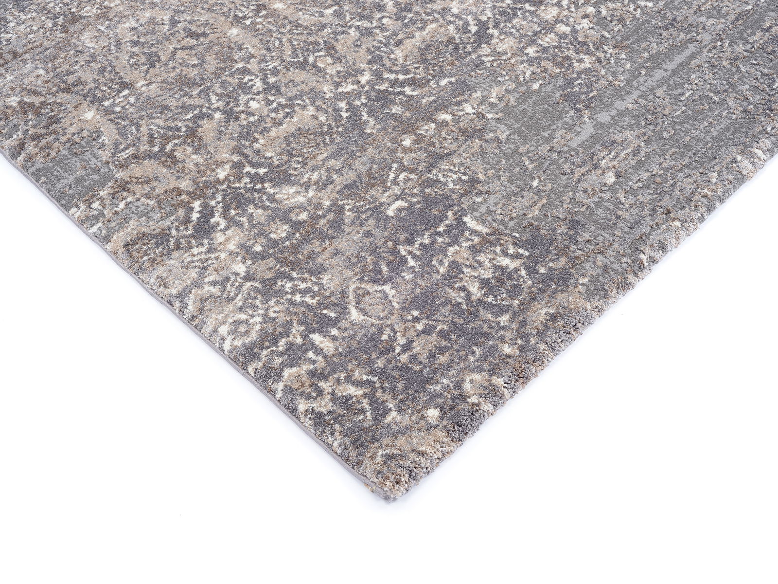 Designer Teppich in Grau- und Beigetönen mit abstraktem Muster, perspektivisch von der Seite fotografiert.