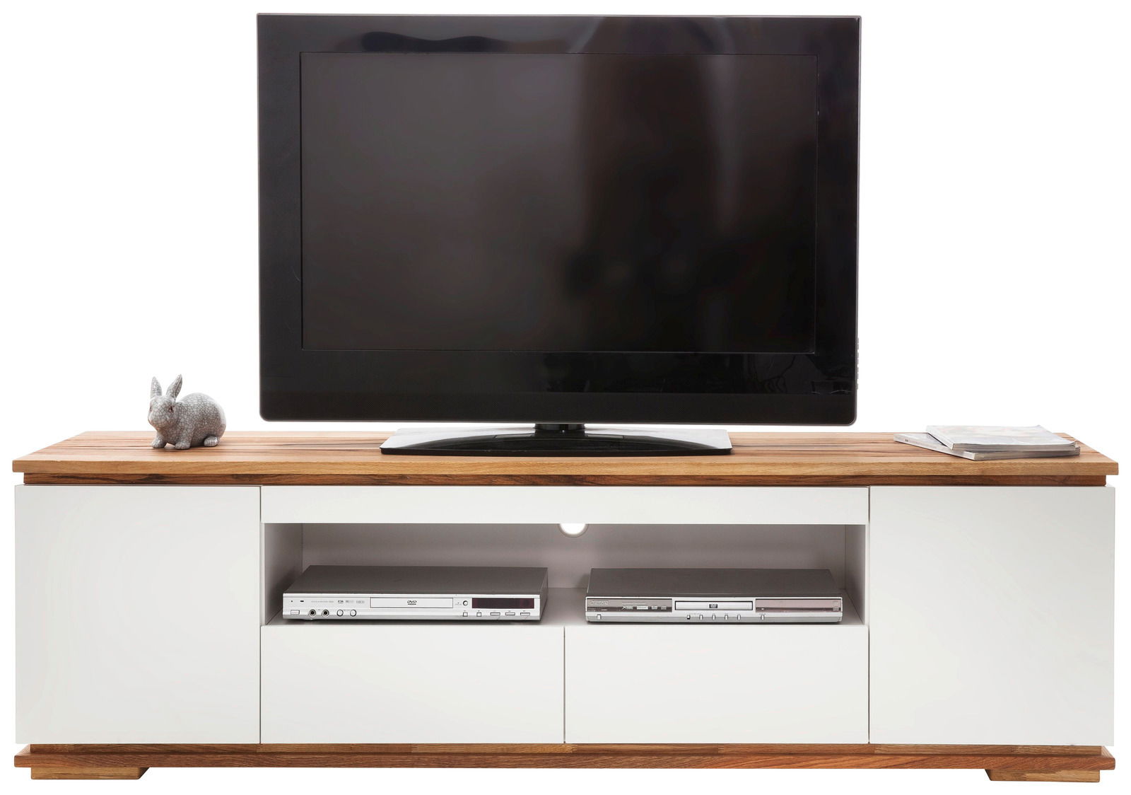 Frontansicht eines TV-Lowboards mit Holzoberfläche, weißem Korpus, einem Fernseher, einem Deko-Hasen und zwei elektronischen Geräten in der Mitte.