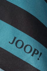 Nahaufnahme von gestreifter Bettwäsche mit dem Schriftzug 'JOOP!' in Blau und Schwarz.