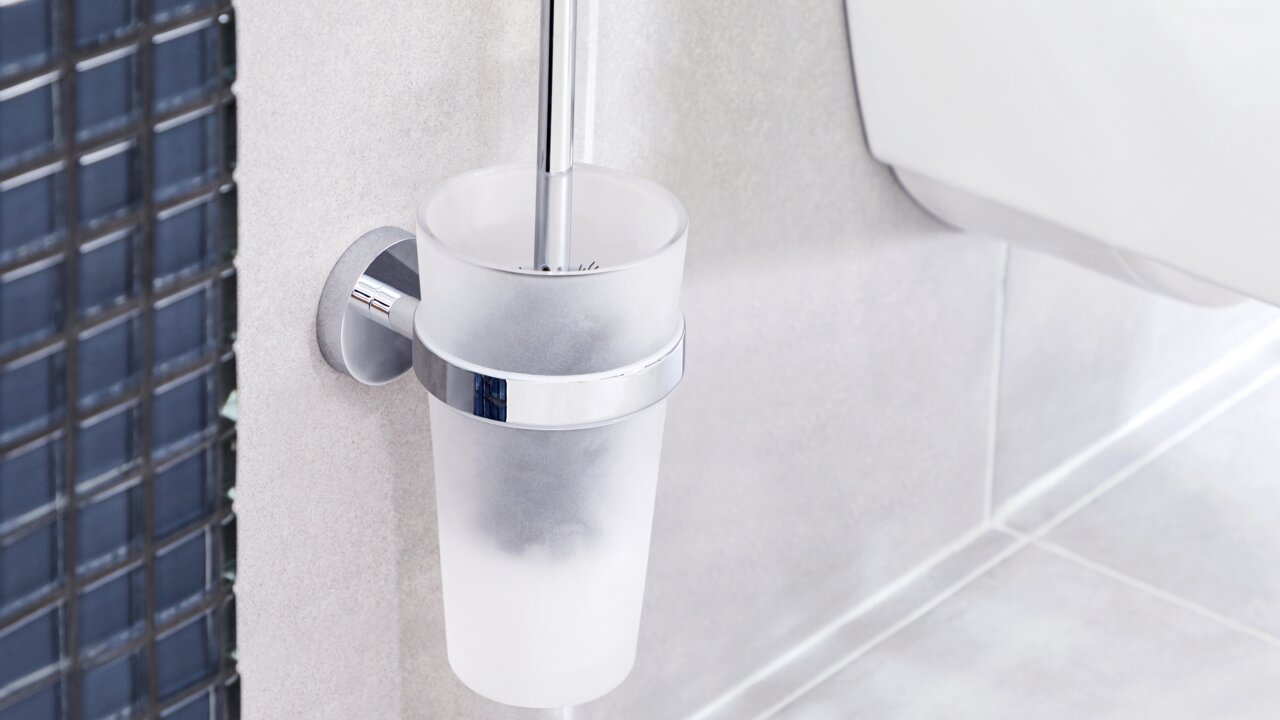 Wandmontierte WC-Bürste in einem matten Glasbehälter mit Chromhalterung, seitliche Perspektive