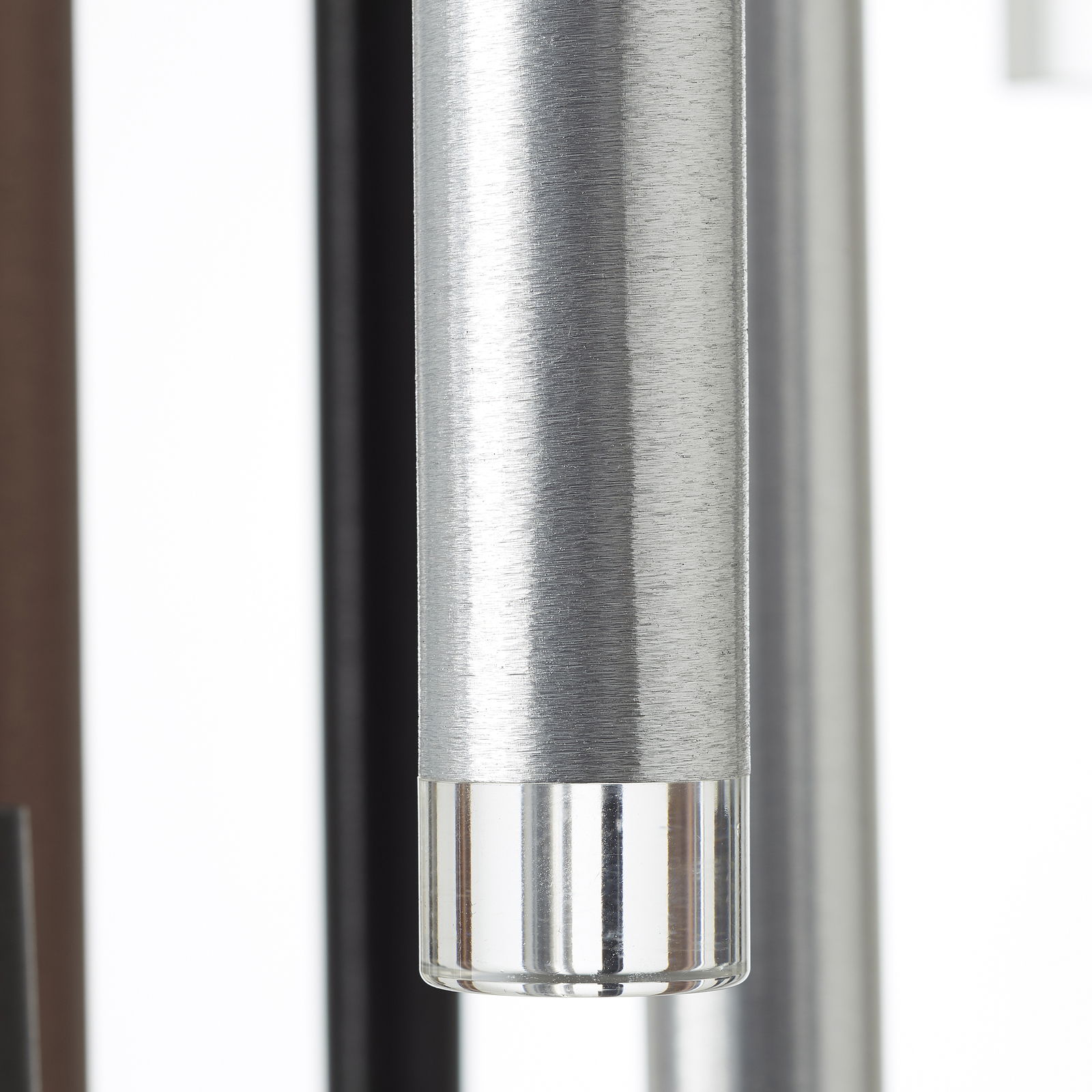 Nahaufnahme eines zylindrischen Metallteils mit gebürsteter Oberfläche und transparentem Ende, seitliche Perspektive