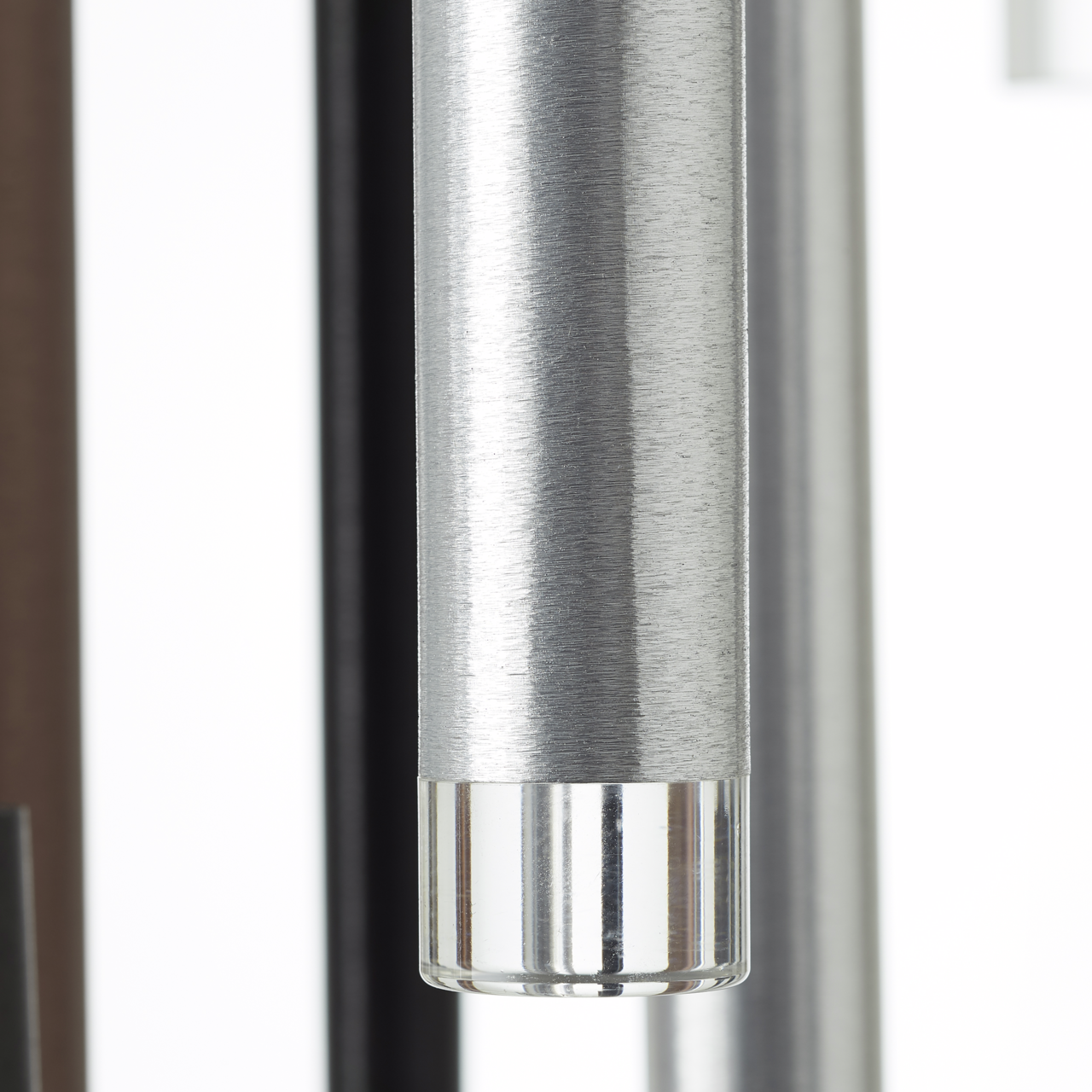 Nahaufnahme eines zylindrischen Metallteils mit gebürsteter Oberfläche und transparentem Ende, seitliche Perspektive
