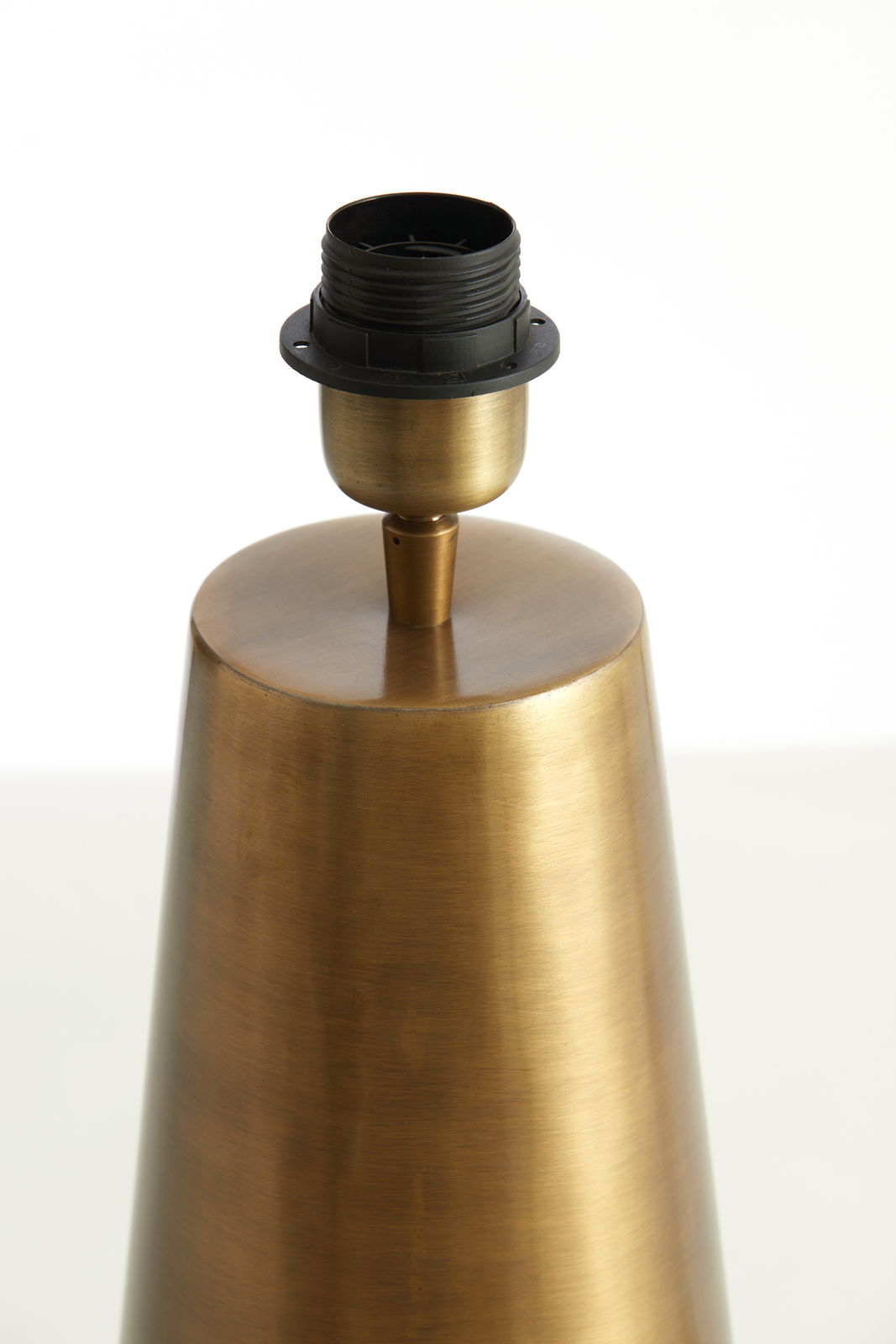 Nahaufnahme eines konischen Lampenfußes aus gebürstetem Metall mit einer schwarzen Lampenfassung, seitliche Perspektive.