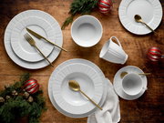 Weißes Porzellan-Geschirrset mit Tellern, Schalen und Tassen sowie goldfarbenem Besteck auf rustikalem Holztisch mit weihnachtlicher Deko, Draufsicht (Flatlay)