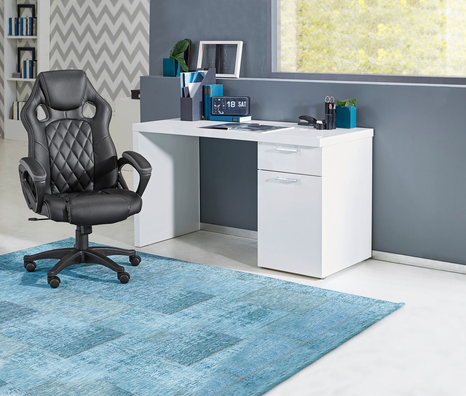 Moderner Gaming-Stuhl in Schwarz vor einem weißen Schreibtisch, seitliche Perspektive.