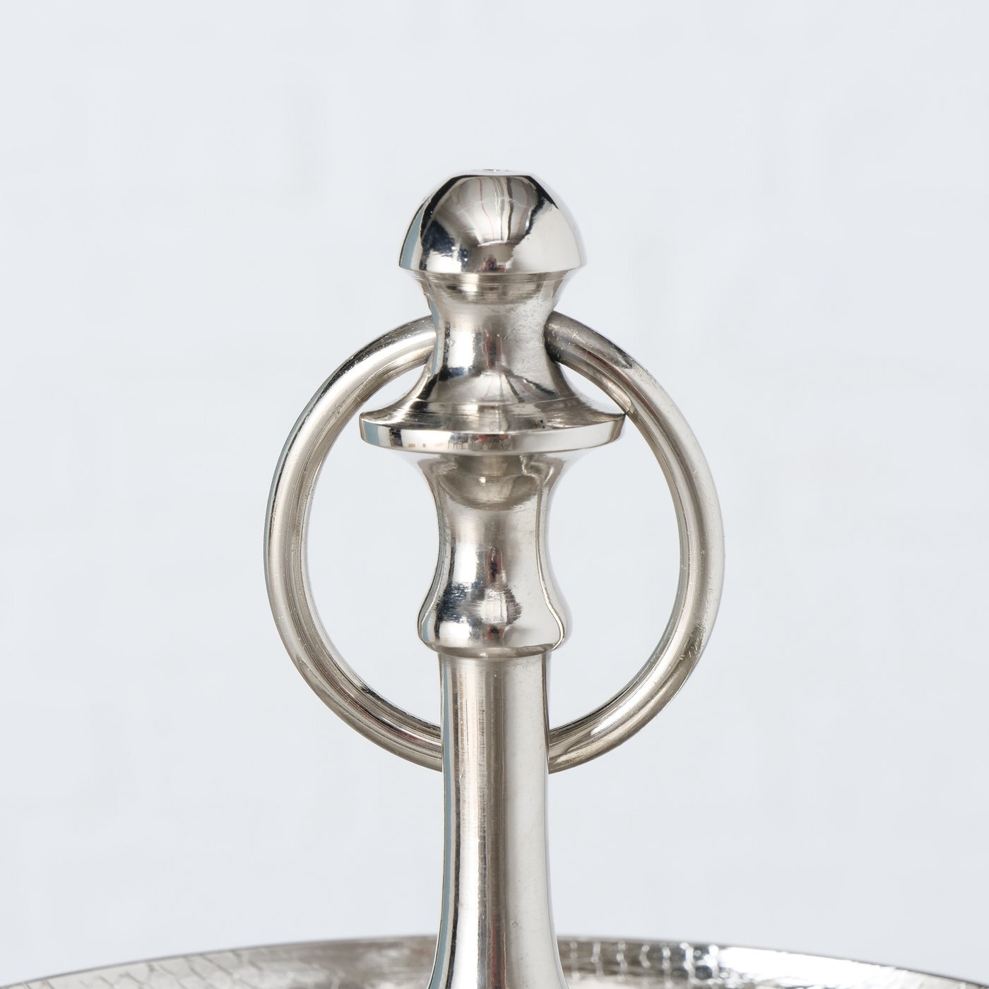 Boltze Etagere H 30cm PASSIA Nahaufnahme des oberen Teils einer silbernen Etagere mit einem dekorativen Griff und einem Ring, aus Aluminium gefertigt.