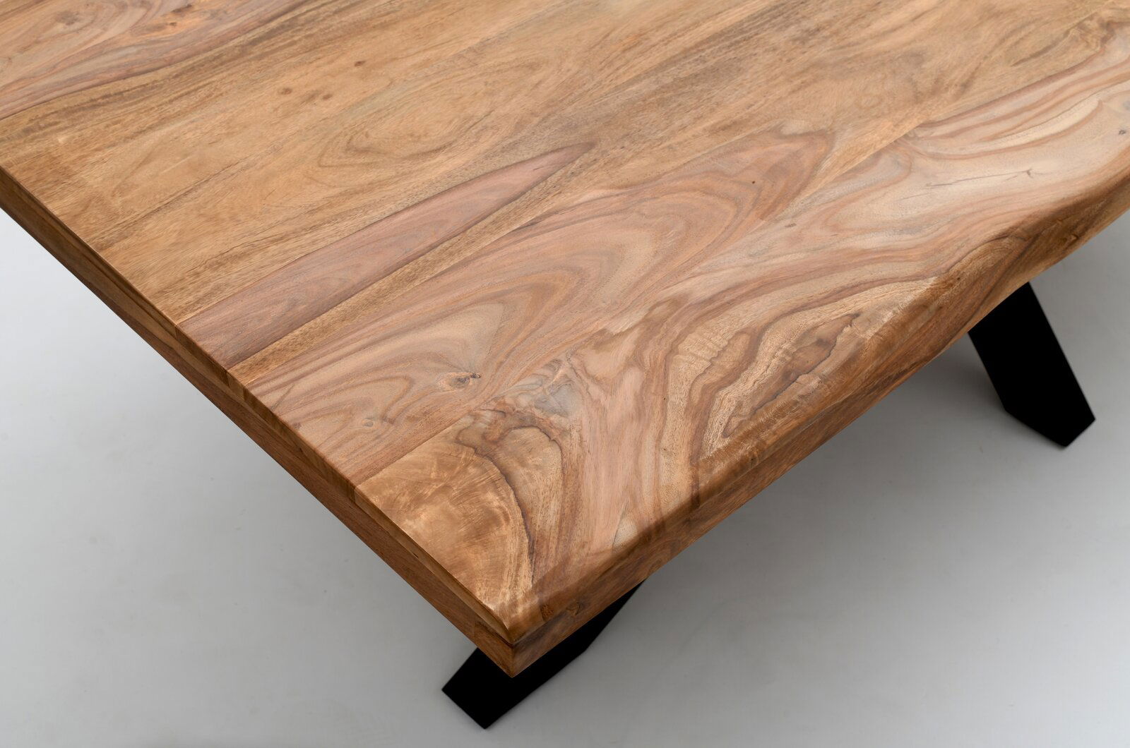 Landscape Esstisch DOMINO Nahaufnahme eines Esstisches aus Holz mit natürlicher Maserung und schwarzen Metallbeinen, aus der Vogelperspektive fotografiert.