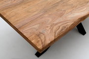 Nahaufnahme eines Esstisches aus Holz mit natürlicher Maserung und schwarzen Metallbeinen, aus der Vogelperspektive fotografiert.