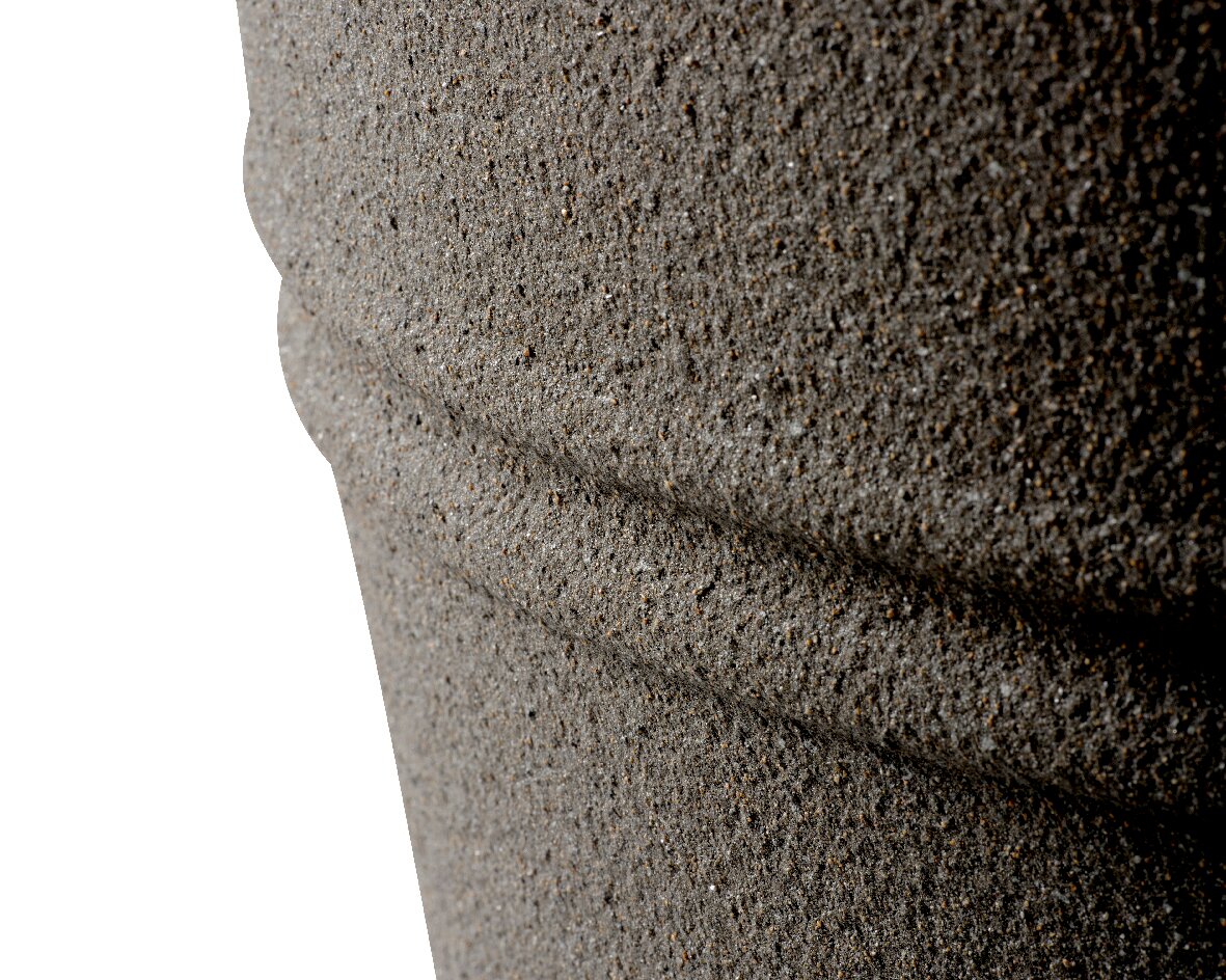 Nahaufnahme eines strukturierten, grauen Kunststoffmaterials mit horizontalen Rillen, seitliche Perspektive.