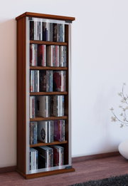 Schmales CD-/DVD-Regal aus Holz mit silberfarbenen Seitenleisten, gefüllt mit CDs, in Innenraum vor weißer Wand und Holzboden, frontal leicht schräg von vorne aufgenommen.