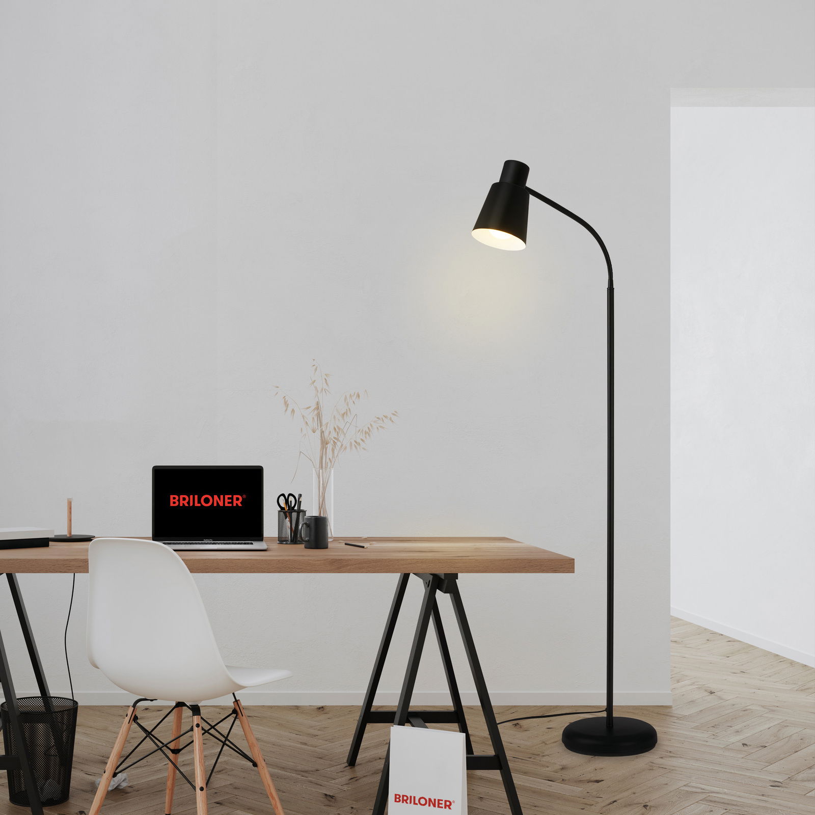Schwarze Stehleuchte mit E27-Fassung neben einem modernen Schreibtisch, seitliche Perspektive.