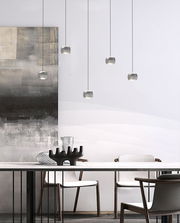 Moderne LED-Pendelleuchte in einem eleganten Esszimmer, aus der Seitenperspektive fotografiert.