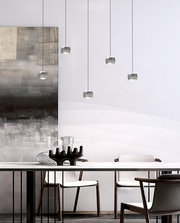 Moderne LED-Pendelleuchte in einem eleganten Esszimmer, aus der Seitenperspektive fotografiert.