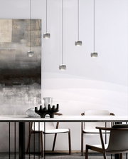 Moderne led-hanglamp in een elegante eetkamer, gefotografeerd vanuit een zijaanzicht.