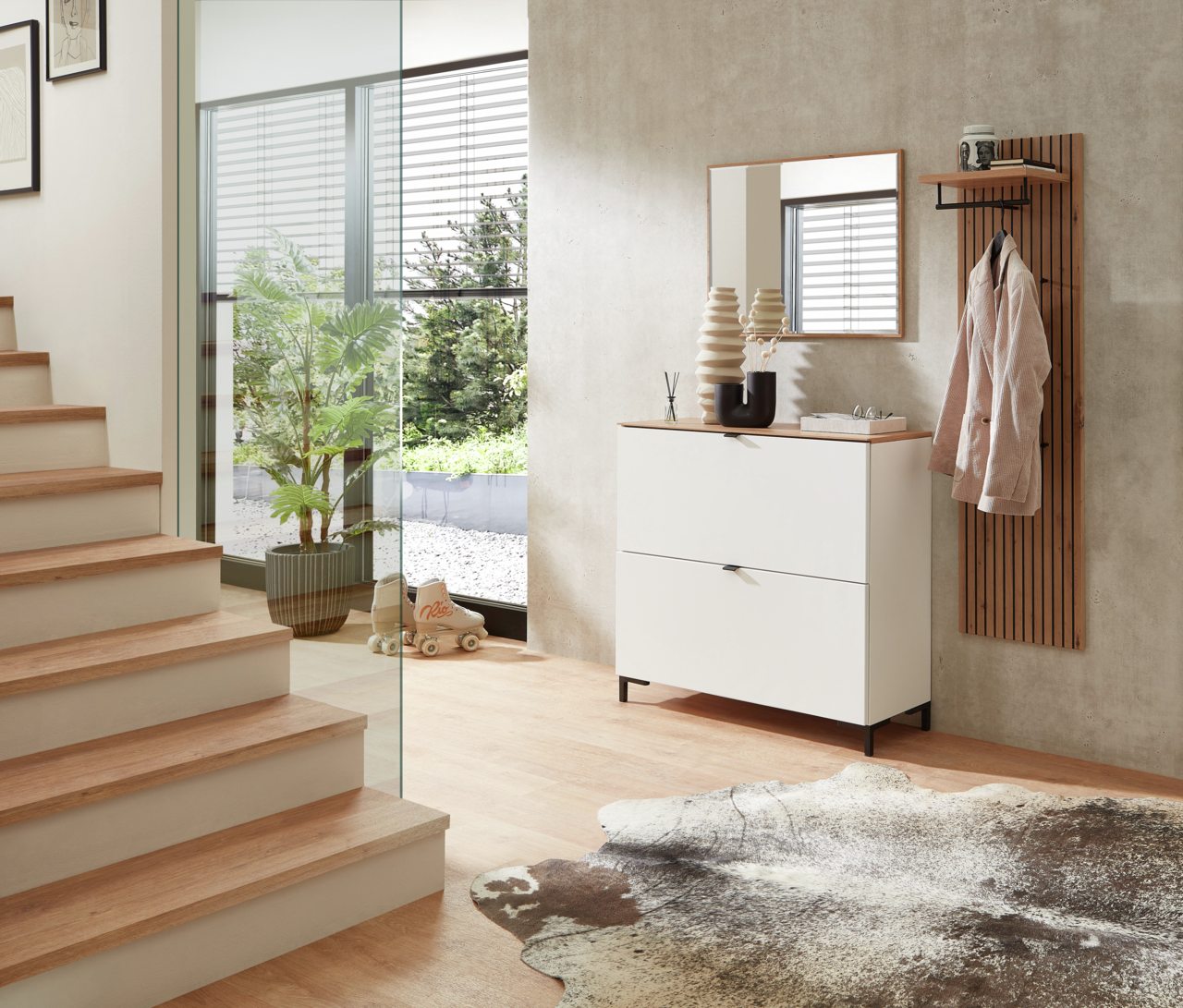 Moderner Eingangsbereich mit weißem Garderoben-Hängeschrank, Spiegel und Garderobenpaneel aus Holz, seitliche Perspektive.