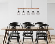 Moderne Hängeleuchte mit fünf Glühbirnen in Käfigdesign, aufgehängt an einem Holzbalken über einem Esstisch, aus der Vorderansicht.