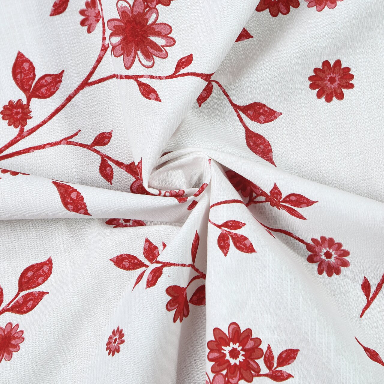 Close-up van een witte stof met rode bloemen- en bladmotieven, in het midden kunstig gedrapeerd.