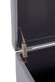 Detailaufnahme aus seitlicher Perspektive: geöffnete graue Aufbewahrungsbox mit Stoffbezug und Metall-Scharnier/Deckelhalterung im Innenraum