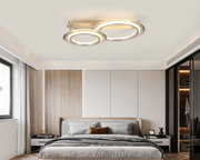 Moderne LED-Deckenleuchte mit zwei runden Leuchtringen, installiert in einem stilvollen Schlafzimmer, Perspektive von unten.