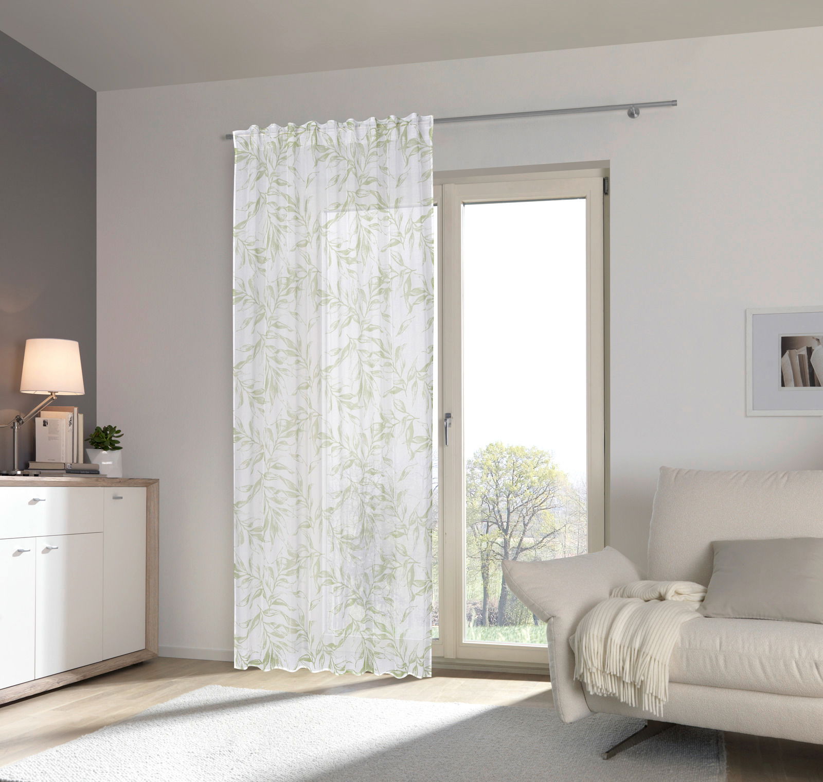 Fertigvorhang Flora 140x245 mit zartem Blattmuster, aufgehängt vor einer Terrassentür in einem modernen Wohnzimmer, seitliche Perspektive