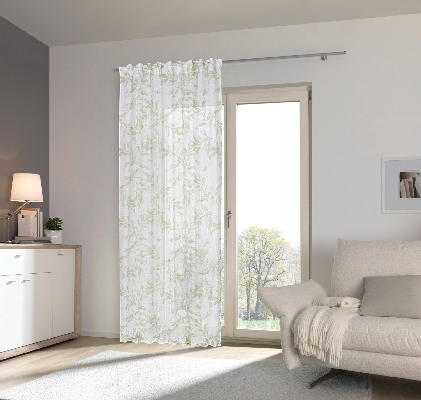 Fertigvorhang Flora 140x245 mit zartem Blattmuster, aufgehängt vor einer Terrassentür in einem modernen Wohnzimmer, seitliche Perspektive