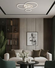 Moderne LED-Deckenleuchte mit kreisförmigem Design, von unten betrachtet in einem stilvollen Wohnzimmer mit Sofa und Kunstwerk an der Wand.