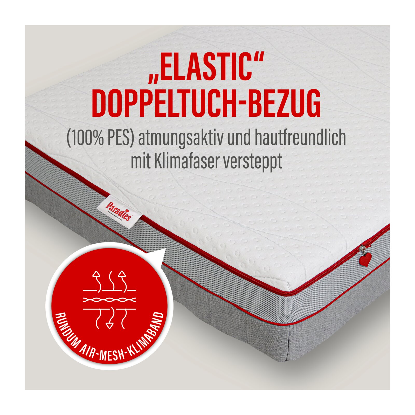 Matratze mit weißem „Elastic“ Doppeltuch-Bezug (100% PES), atmungsaktiv und hautfreundlich, mit Klimafaser versteppt, grauen Seiten und roter Keder/Zip-Umrandung, gezeigt in schräger Draufsicht von oben.