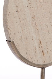 Nahaufnahme eines runden Steins mit natürlicher Textur, gehalten von einem metallischen Ständer, seitliche Perspektive.