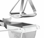 Nahaufnahme einer Edelstahl-Kartoffelpresse COMFORT aus seitlicher Perspektive, die den Hebelmechanismus und den perforierten Behälter zeigt.