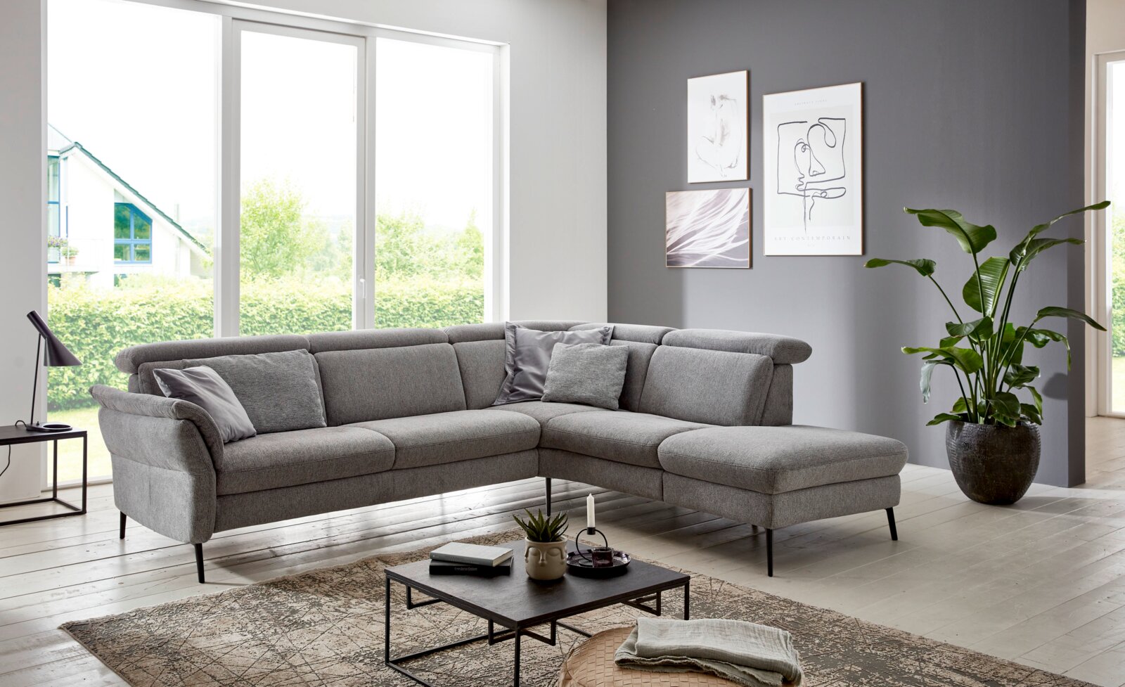 Graue Eckgarnitur in modernem Wohnzimmer, seitliche Perspektive
