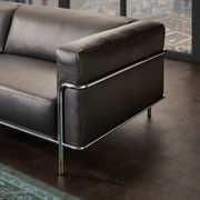 Modernes 3er-Sofa mit schwarzem Lederbezug und verchromtem Metallrahmen, seitliche Perspektive.