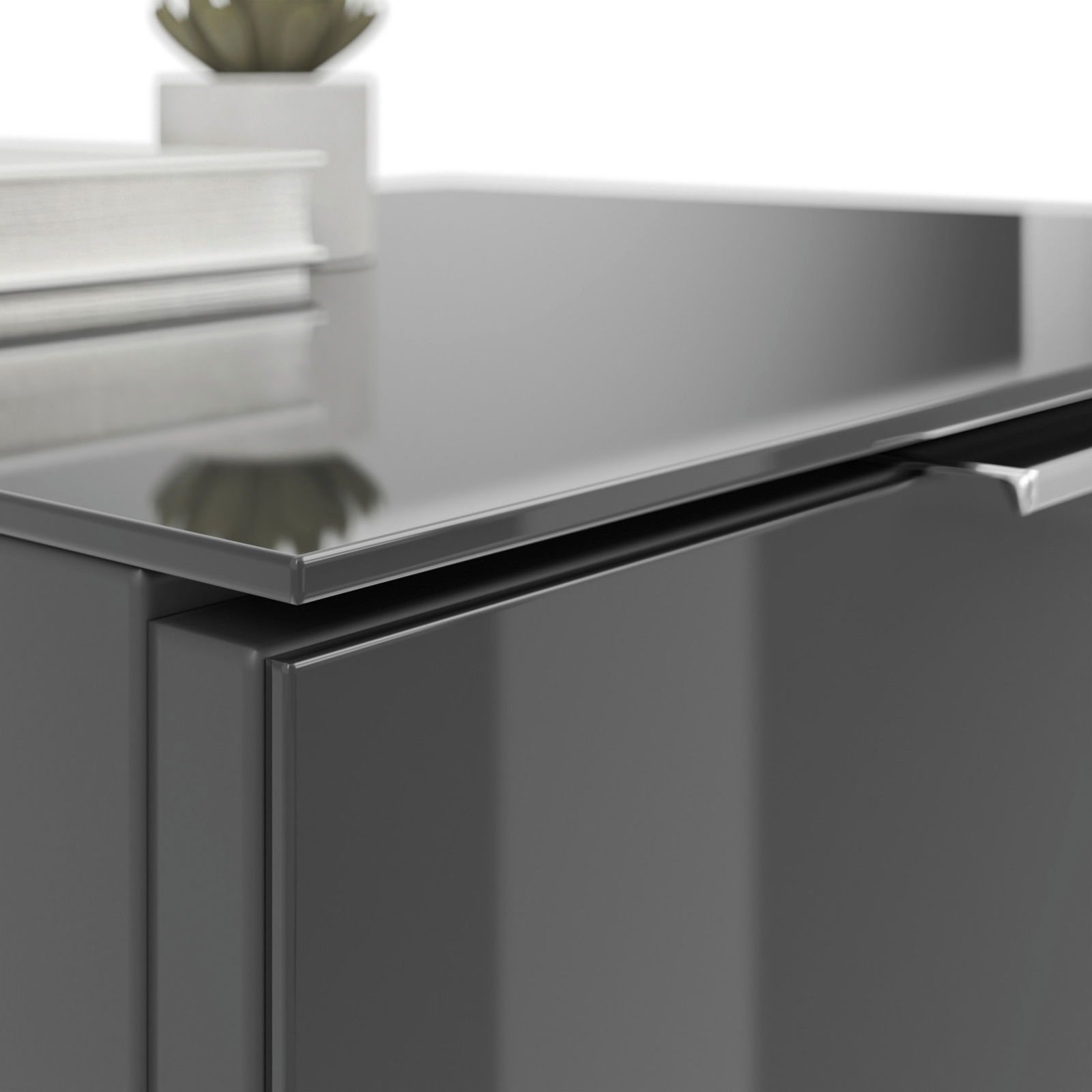 Nahaufnahme einer modernen, glänzenden Nachtkommode in dunkler Farbe mit einem Buch und einer Pflanze darauf.