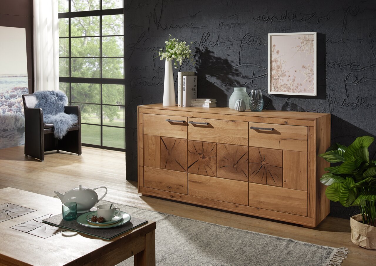 Houten dressoir MERAN in een moderne woonkamer, gefotografeerd van voren, met decoratieve vazen en boeken erop.