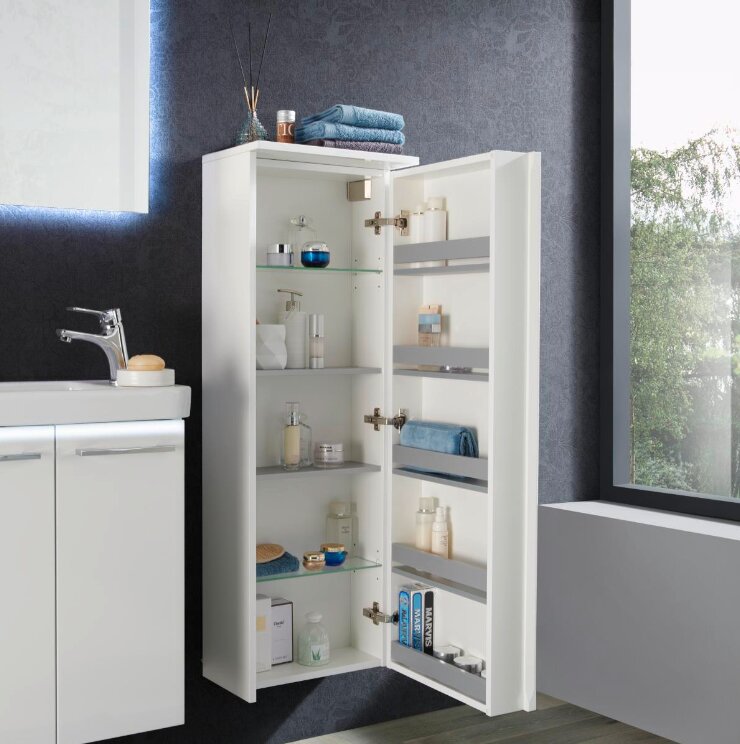 Voleo Kofferschrank rechts LARA Moderner weißer Kofferschrank rechts, geöffnet, mit mehreren Regalen und Pflegeprodukten, seitliche Perspektive