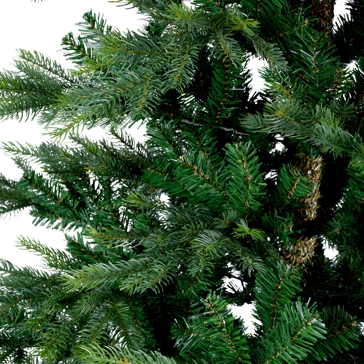 Close-up van groene dennentakken van een kunstkerstboom, gezien vanaf de zijkant.