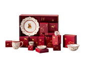 Weihnachtlicher Porzellan-Adventskalender mit 24 roten Geschenkboxen und festlich dekoriertem Geschirr mit Teddybärmotiven, frontal aus leichter Vogelperspektive präsentiert