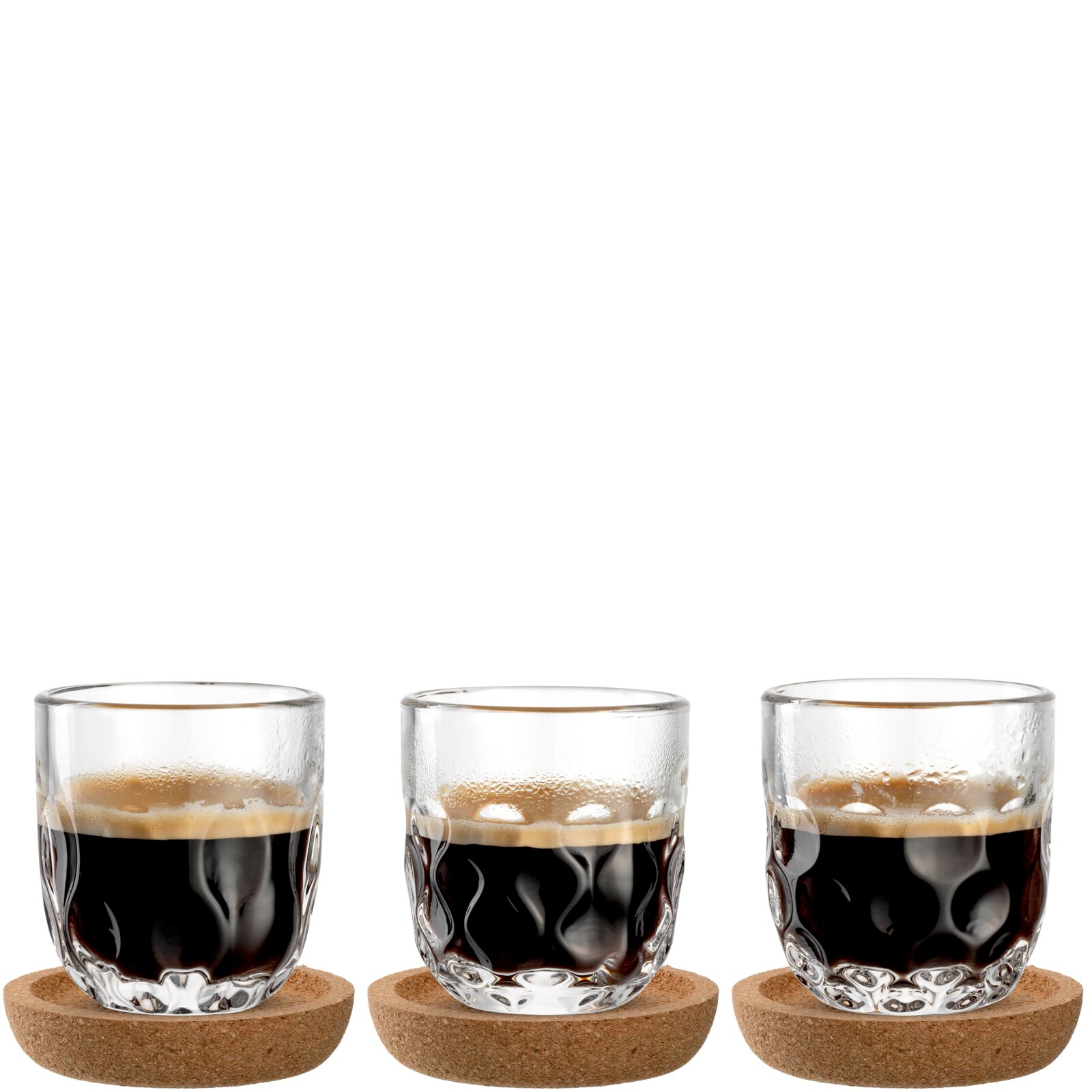 Drei Espressogläser mit gewelltem Design, gefüllt mit Espresso, auf runden Korkuntersetzern, frontal betrachtet.