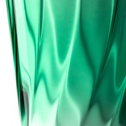 Nahaufnahme eines grünen Trinkglases mit verdrehtem Design, seitliche Perspektive