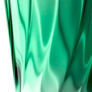 Nahaufnahme eines grünen Trinkglases mit verdrehtem Design, seitliche Perspektive