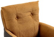 Close-up van een fauteuil met bruine stoffen bekleding en knoopdetails, gezien van bovenaf.