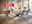 Modernes Esszimmer mit Holz-Tisch, Polsterstühlen und Designerlampe auf Teppich in heller Umgebung, 50%