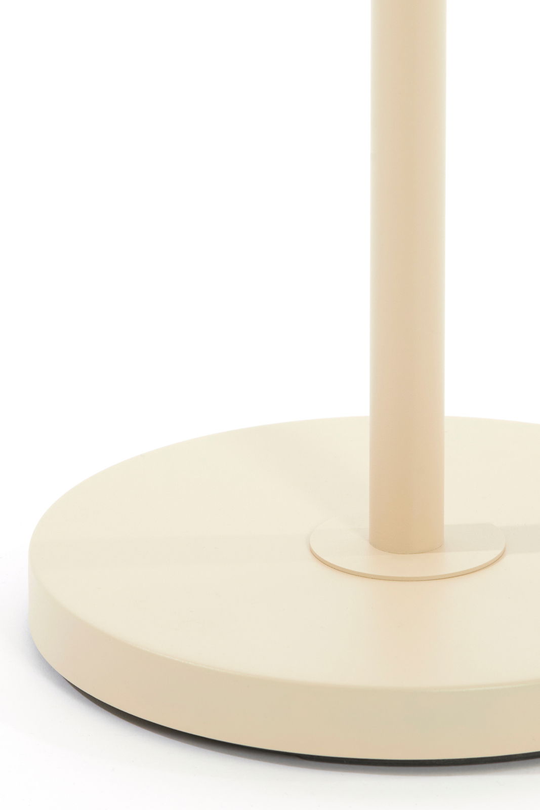 Nahaufnahme der Basis einer Stehleuchte in Beige, von der Seite betrachtet.