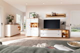 Modernes Sideboard-Set MANITOBA in einem hellen Wohnzimmer, bestehend aus einem hohen Schrank und einem TV-Board mit Holz- und weißen Elementen, aus der Perspektive eines gemütlichen Wohnzimmers mit Blick auf die Möbel.