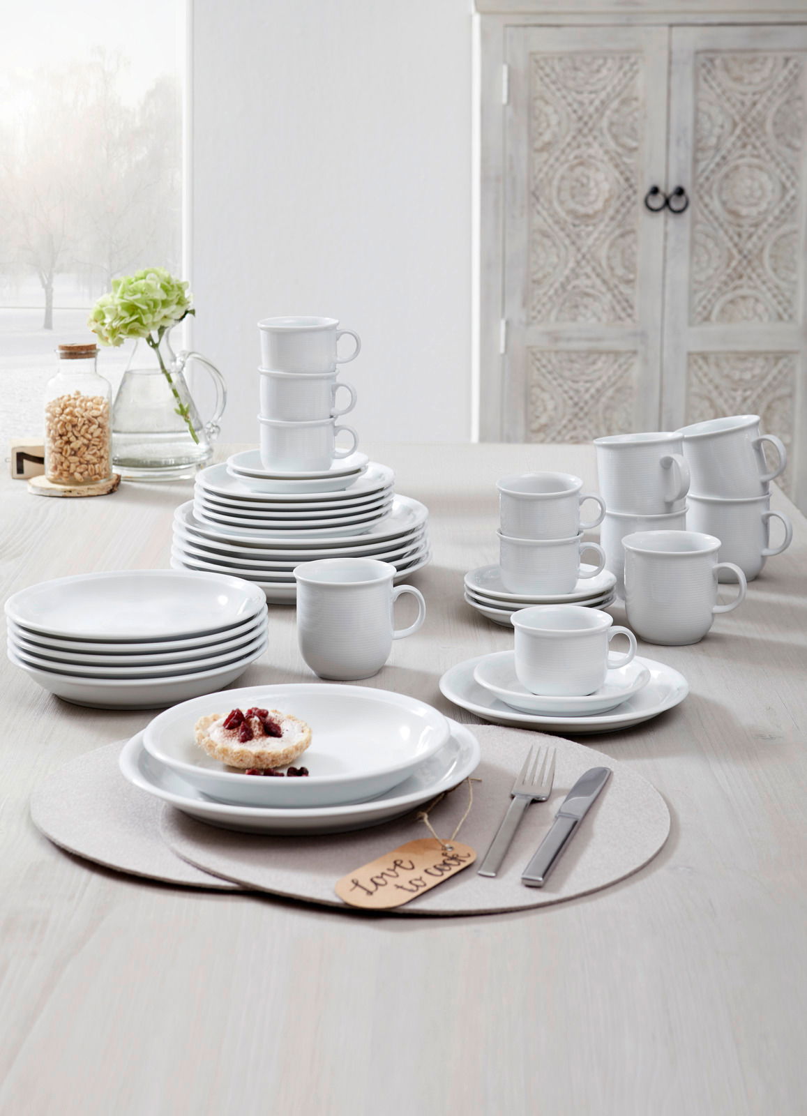 Kombiservice Trend weiß 30-tlg, bestehend aus Tellern, Tassen und Schalen, auf einem Tisch arrangiert, seitliche Perspektive.