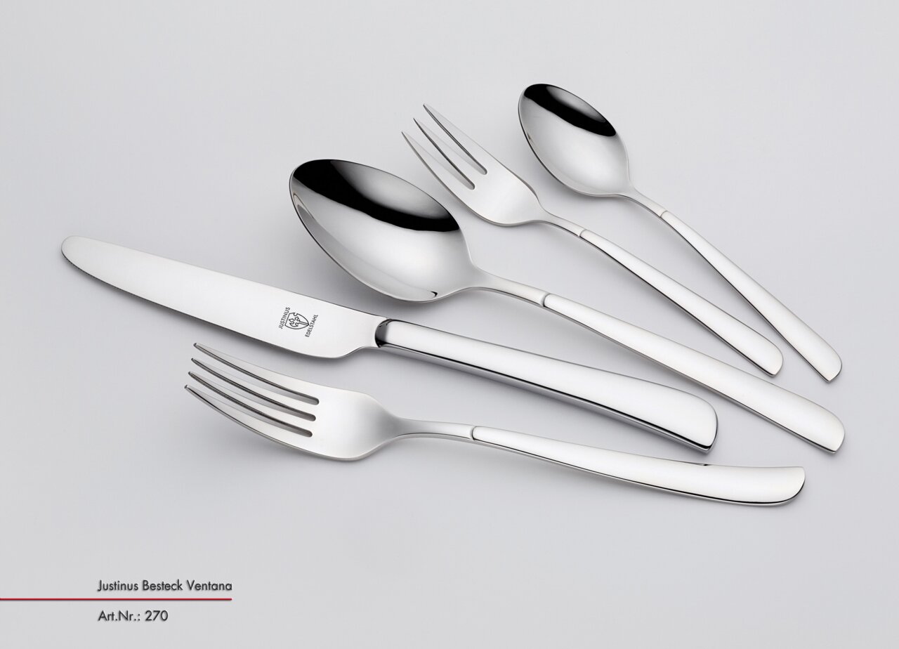 Set aus glänzendem Edelstahlbesteck, bestehend aus Messer, Gabel, Löffel und Teelöffel, in seitlicher Perspektive.