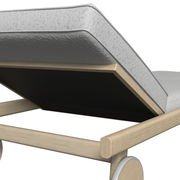 Nahaufnahme einer Sonnenliege mit hellem Holzrahmen und grauer Polsterung, seitliche Perspektive