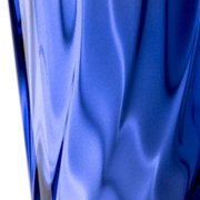 Nahaufnahme eines blauen Trinkglases mit gedrehtem Design, seitliche Perspektive