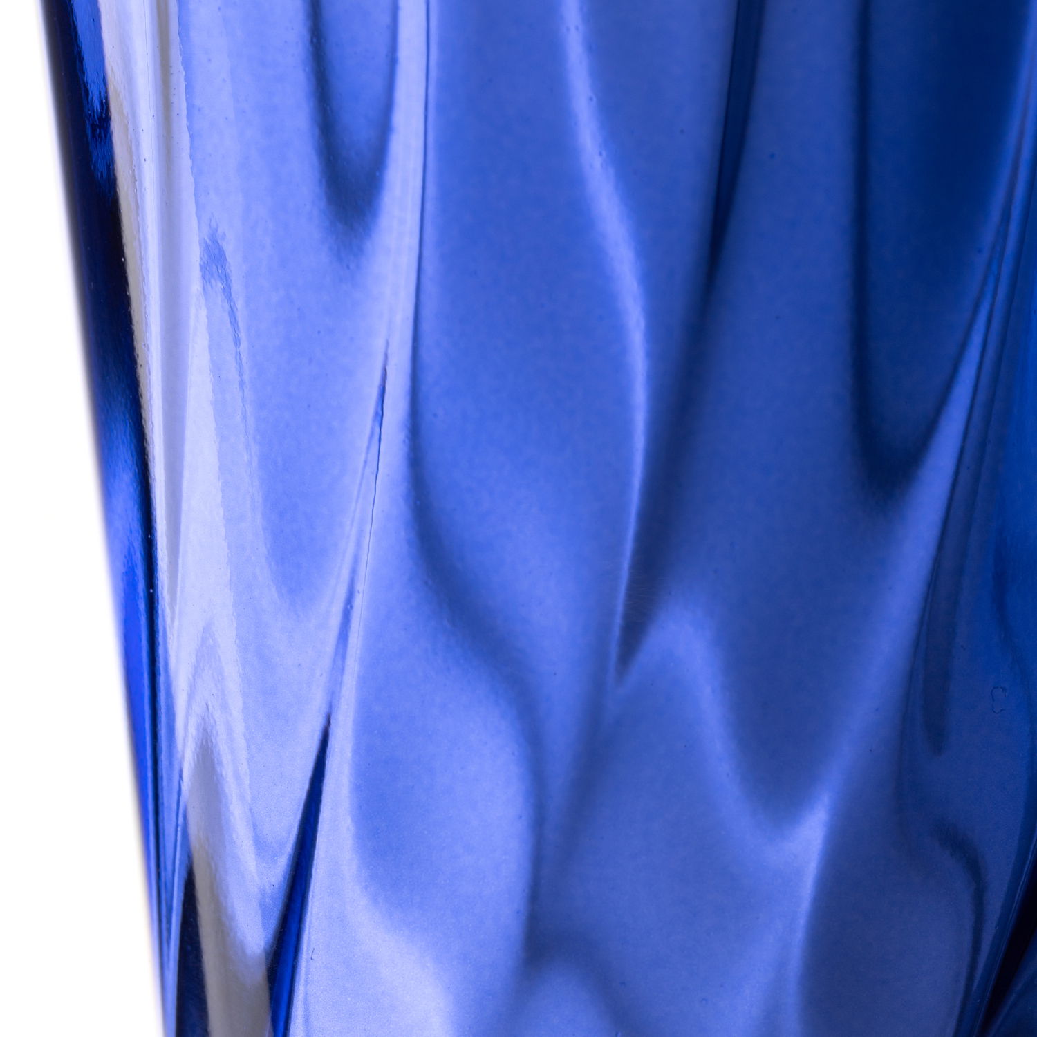 Nahaufnahme eines blauen Trinkglases mit gedrehtem Design, seitliche Perspektive